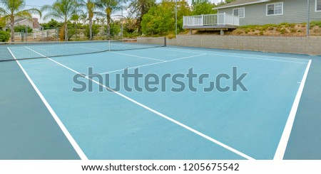 Tennis court with houses in the surrounding area