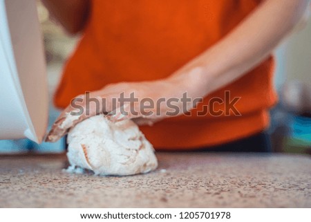 Woman hand kneading dough