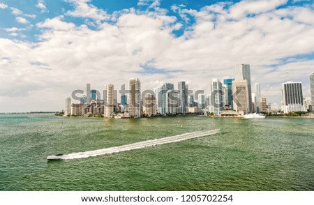 Miami skyscrapers with blue cloudy sky,yacht or boat sailing next to Miami downtown, Aerial view, south beach