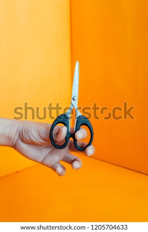 Scissors on orange background