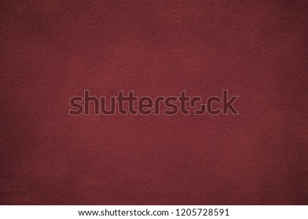 Background of dark red suede fabric closeup. Velvet matt texture of wine nubuck textile with gradient. Marron felt backdrop, vignette. Royalty-Free Stock Photo #1205728591