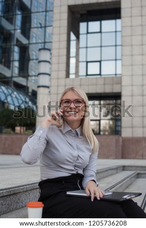 Happy woman using phone outdoors.