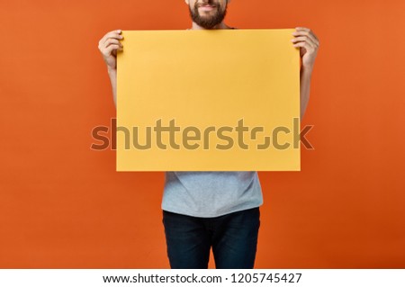 man with an orange sheet of paper in his hands                           