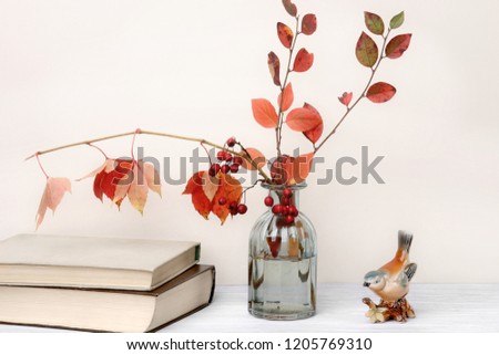 Composition of books and autumn leaves in interior. Autumn still life with decorative bird, books and bouquet.
 Royalty-Free Stock Photo #1205769310