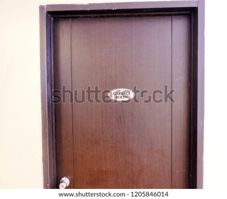 Wood door with garbage room text sign 