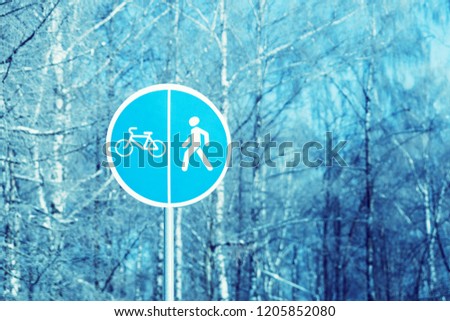 Sign in the park to separate the bike and pedestrian paths, winter landscape.