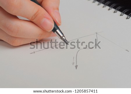 Hand holding pen and drowing graph on white sheet