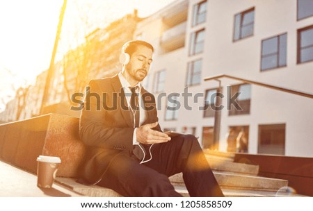 Young businessman with headphone and tablet computer while video streaming
