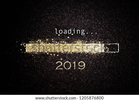 Computer screen with loading bar counting down for New Years Eve 2019 with sparkling glitter and copy space over black Royalty-Free Stock Photo #1205876800