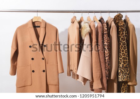 female brown leopard pattern clothes, coat, jacket, brown sweater on hanger


