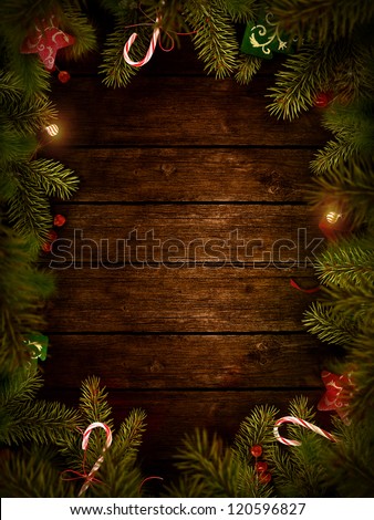 Christmas design - Merry Christmas. Xmas wreath card with with copyspace on wooden background. Christmas ornaments on wood with candy and ribbons.