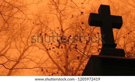 Autumn cross at the old dark cemetery