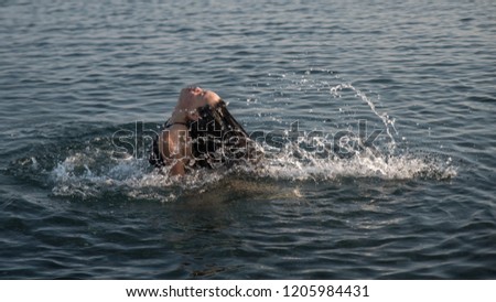 teen flipping hair in water and making a splash
