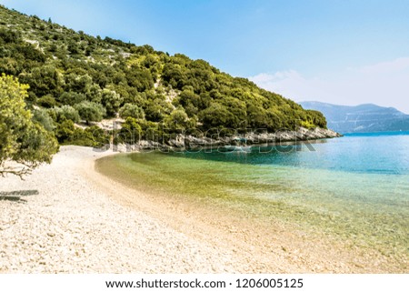 Empty beach with a boat on water at sunny day. Kefalonia island, Greece.