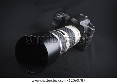 Professional digital photo camera with zoom lens on black background