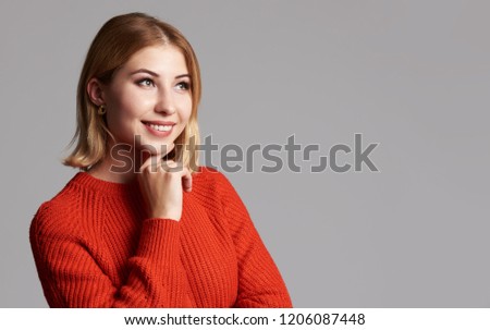Beautiful caucasian woman wearing red sweater. Isolated on gray studio background