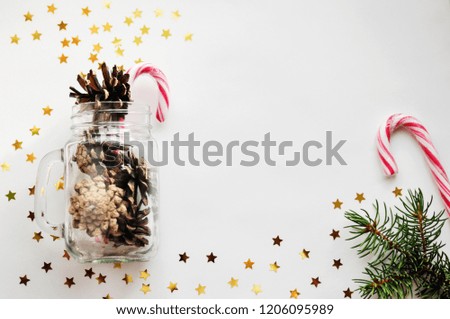 Magic Christmas card with shining stars and cones in a glass jar and caramel. Flat lay, top view