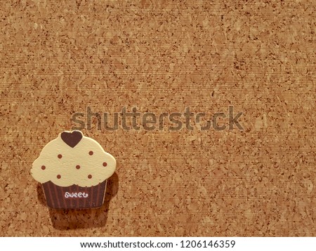 Background is Medium Density Fiberboard is engineered wood wallboard made of wood chips and other recycled materials and copy space right side to put text and pictures on demand and has Cupcake shape.