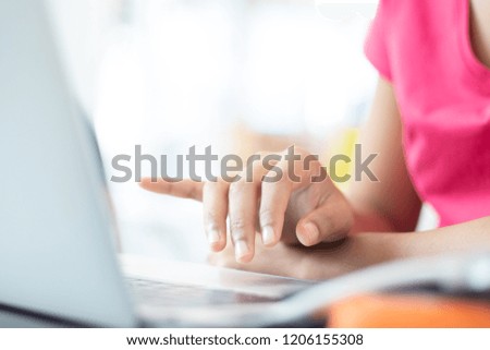 The hand of a woman typing the laptop.