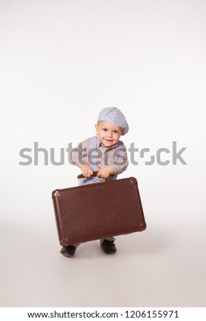 Little boy - child holds in his hands an old vintage suitcase isolated on white background