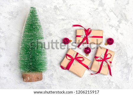 Happy new year composition. Christmas decoration gifts, glitter, Christmas balls, candy, snowflakes on gray concrete  background. Flat lay, top view.