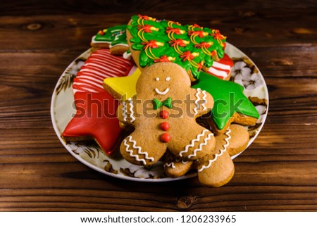 Plate with different christmas gingerbread cookies on rustic wooden table