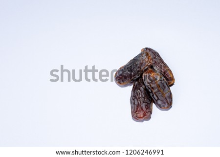 A group of delicious madjool dates on white background for the Islamic celebration for breaking fast during Ramadan.