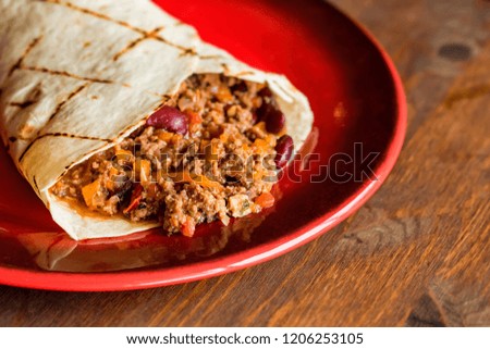 Delicious burrito with minced meat on plate close