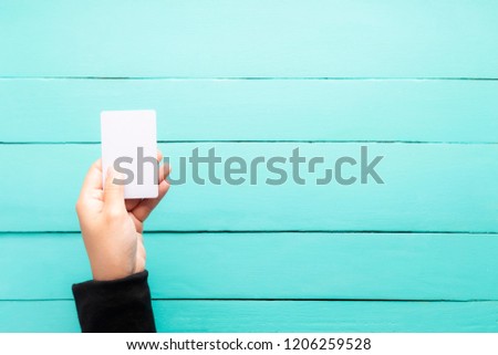 Hand holding blank business card on vintage green wooden floor, blank name card with copy-space. 