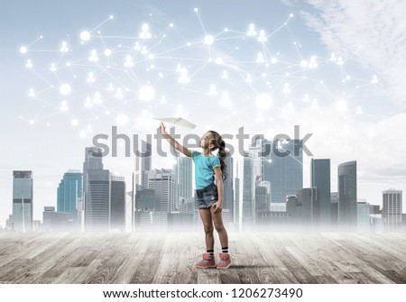Cute kid girl standing on wooden floor and play with plane