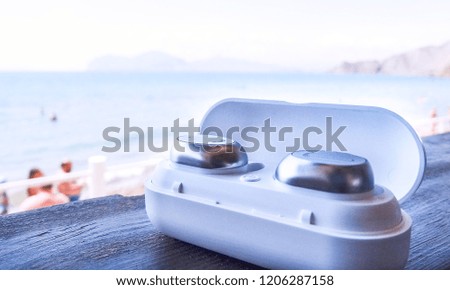       Wireless headphones in a white box on the background of the sea
                         