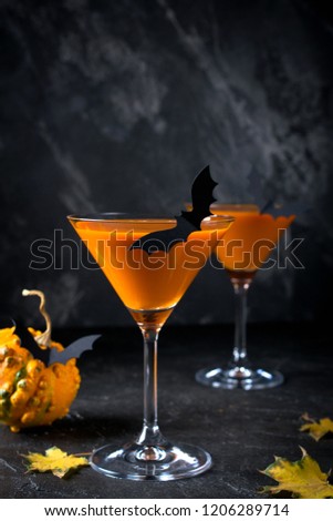 Halloween orange drink with  bats on dark background, spooky