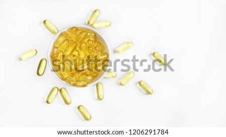 Top view(Flat lay) of Gold Fish oil gel capsules concentrated in white a cup isolated on white background view.