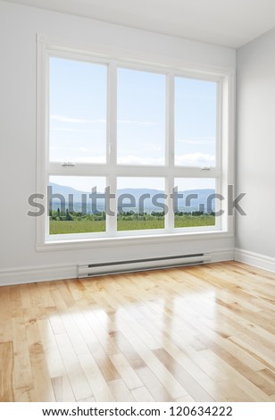 Summer landscape seen through the big window of an empty room. Royalty-Free Stock Photo #120634222