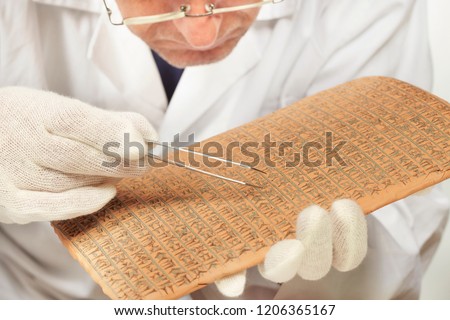 Scientist exploring ancient type of Akkad empire style cuneiform with tweezers