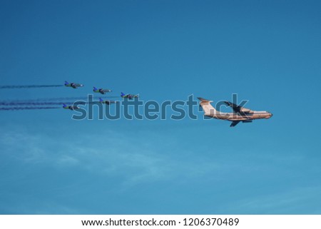 A fighter link escorts a transport plane. Cargo aircraft escorted by five military jets.