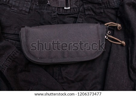 Nylon wallet. Tactical organizer. Black wallet on a black background. Top.