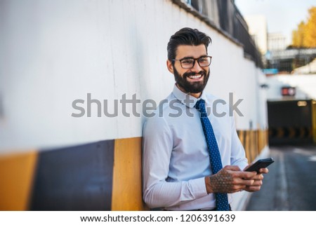 Young businessman carries out its corporate business outside and talking on the phone.