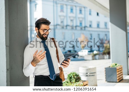 Young businessman carries out its corporate business outside and talking on the phone.