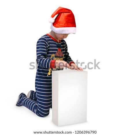 Happy boy in pajamas unpacks Christmas presents isolated on white background photo