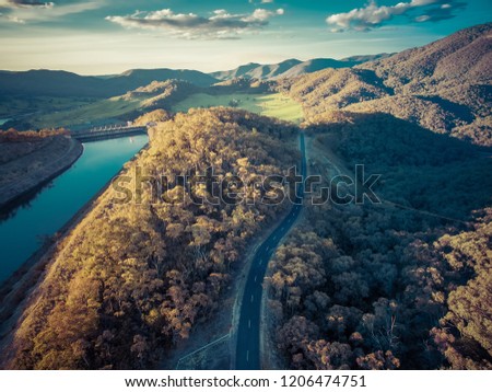 Rural road passing through hills and mountains at sunset