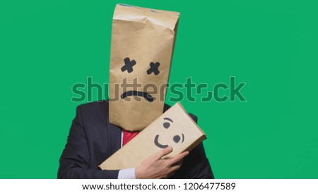 concept of emotions, gestures. a man with a package on his head, with a painted emoticon, tired, sleepy. plays with the child painted on the box.
