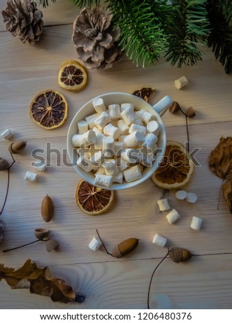 autumn still life with hot cocoa, marshmallows, pine and cones, lemon, leaves, on white wooden background top view. object group