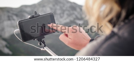 Hiking woman taking panoramic picture of summer mountain landscape. Selfie photo stick. Zabljak Durmitor, Montenegro
