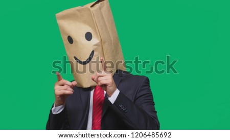 concept of emotions, gestures. a man with paper bags on his head, with a painted emoticon, smile, joy
