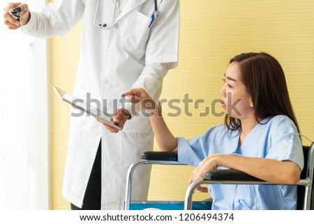 Asian female patient on wheelchair with senior doctor