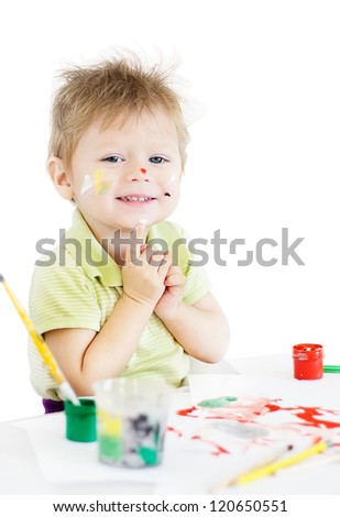Painting smiling funny boy with color paints and brushes