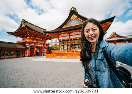 attractive female photographer taking selfie with the Japanese temple in the background. tourist visiting Kyoto Japan. lady lens man taking phone selfie photo.