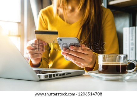 businesswoman hand using smart phone, tablet payments and holding credit card online shopping, omni channel, digital tablet docking keyboard computer at office in sun light
 Royalty-Free Stock Photo #1206514708