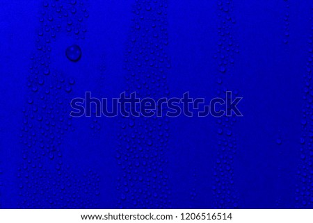 Close up of water drops on sky blue tone background. Abstarct ultramarine wet texture with bubbles on window glass surface. Raindrop, Realistic pure water droplets condensed for creative banner design